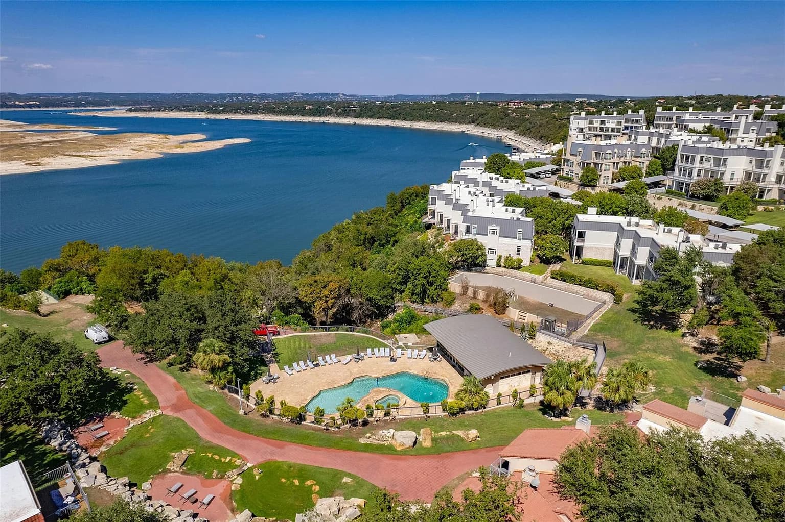 Aerial view of the Villas on Travis gated condo community on Lake Travis in Lakeway, Texas, with the community pool in the foreground